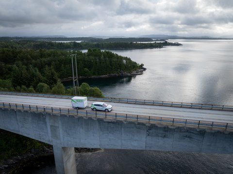 Bil med tilhenger som kjører over bro